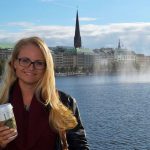 Girl standing in front of Alsterfontäne in Hamburg at Binnenalster