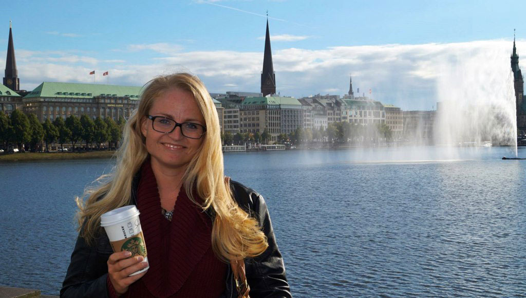 Girl standing in front of Alsterfontäne in Hamburg at Binnenalster