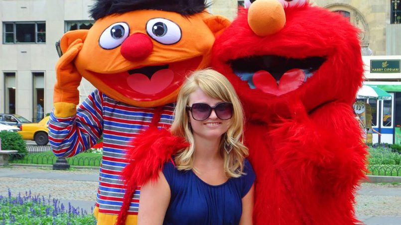 Girl standing in front of Ernie and the Grobie of Sesame Street