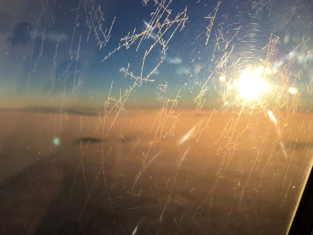 Flugzeugscheibe mit Eiskristallen während Flug - Moments of Travel