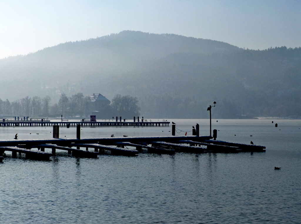 blick auf steg und haus am ossiacher see