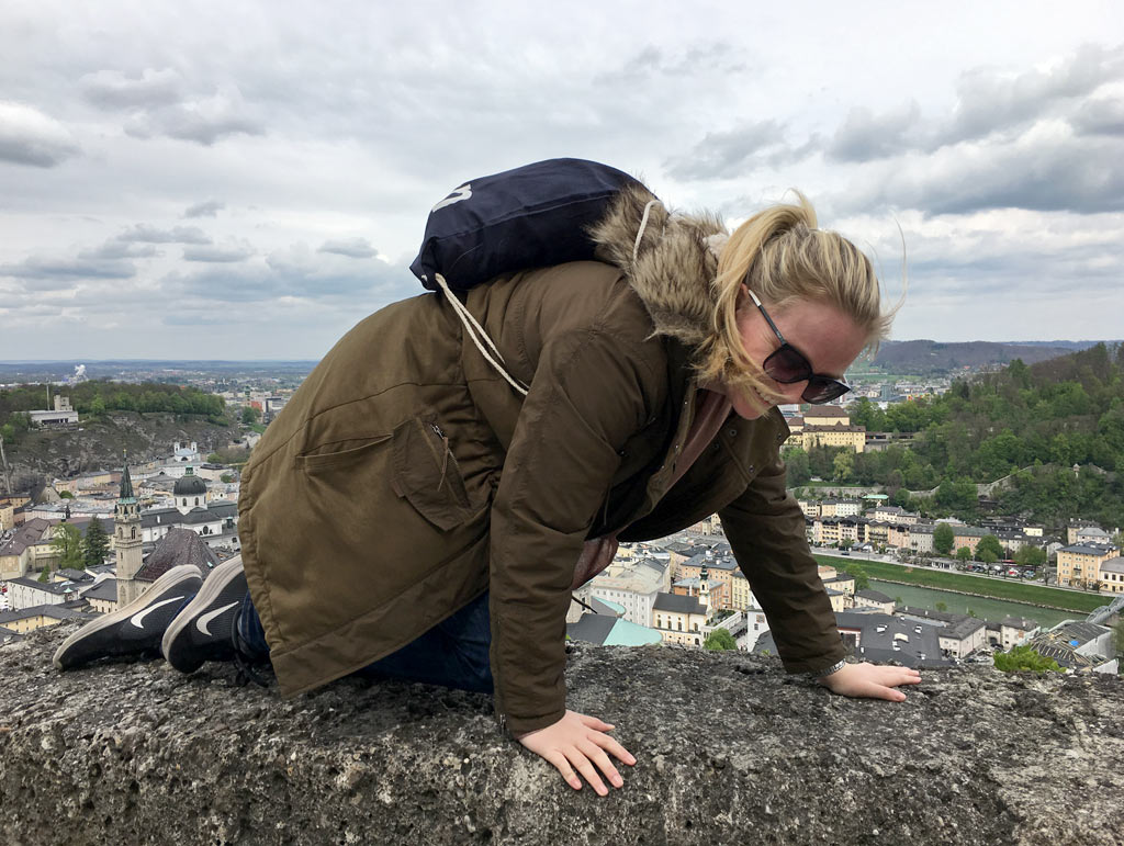 Frau krabbelt auf Mauer